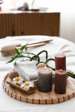 Salondaki kanepede yanan mumlar ve bambuyla kaplıca kompozisyonu, yakın plan.