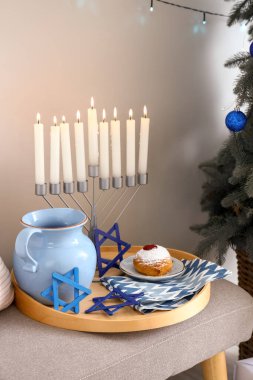 Menoralı tepsi, bankta sürahi ve çörek, yakın plan.