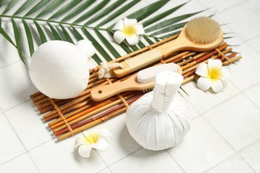 Kaplıca aksesuarları, palmiye yaprağı ve açık fayanslı tropikal çiçekli kompozisyon