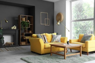 Dekoratif şömine rafı ve kanepesi olan oturma odasının içinde.