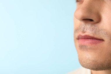 Mavi arka plandaki genç adam, yakın plan.