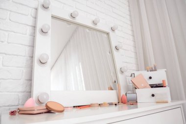 Makyaj odasında kozmetik ve ayna olan çekmeceler.