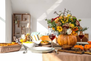 Şenlikli yemek masasında sonbahar çiçekli balkabağı, yakın plan.