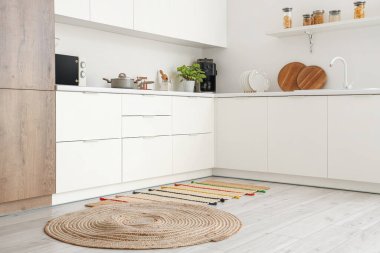 Mutfağın içi tezgah ve halılarla dolu.