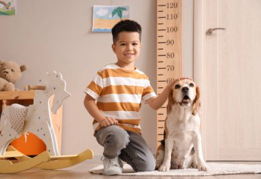 Evinde sevimli köpeği olan küçük Asyalı çocuk.