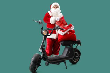 Noel Baba, Noel hediyeleriyle dolu bir çantayla elektrikli scooter ile turkuaz arka planda.