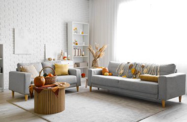 Balkabağı ve kanepelerle dolu oturma odasının içinde.