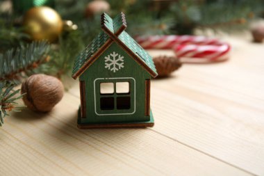 Bej ahşap arka planda Noel süslemeleri olan güzel köknar dalları