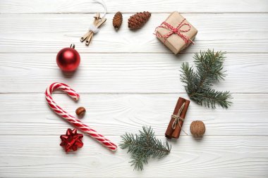 Noel topları ve beyaz ahşap arka planda hediye kutusu olan güzel köknar dalları
