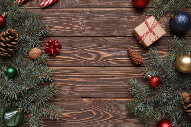 Noel süsleri ve kahverengi ahşap arka planda hediye kutuları olan güzel köknar dalları.