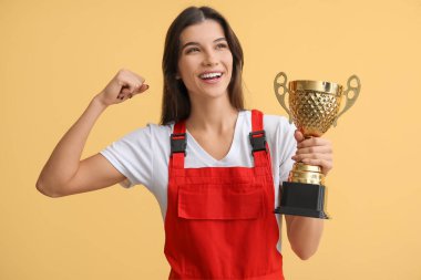 Sarı arka planda altın bardaklı kadın işçi.