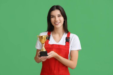 Yeşil arka planda altın bardağı olan kadın işçi.