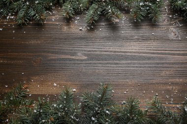 Kahverengi ahşap zemin üzerinde kar olan güzel Noel ağacı dalları