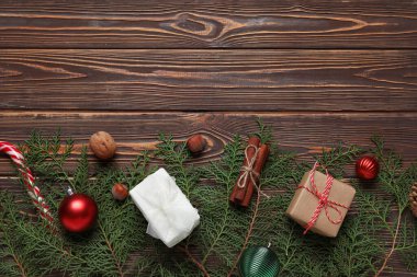 Noel dalları hediyeler ve koyu ahşap arka planda dekor