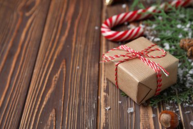 Karlı ve dallı bir Noel hediyesi. Koyu ahşap arka planda. Yakın plan.