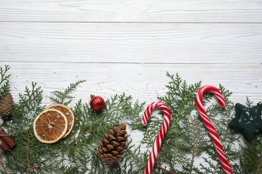Beyaz ahşap arka planda yemek ve dekor bulunan Noel dalları
