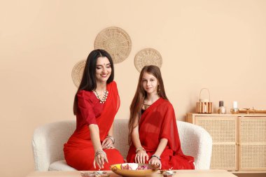 Evinde elinde mumlar, çiçekler ve diya lambaları olan güzel bir anne. Divaly kutlaması