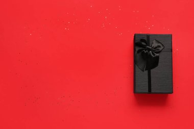 Kırmızı arka planda hediye kutusu. Kara Cuma