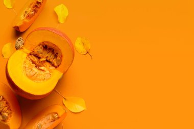 Turuncu arka planda taze balkabağı ve sonbahar yaprakları kes