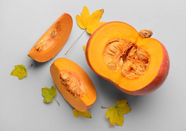 Gri arkaplanda taze balkabağı ve sonbahar yaprakları kes