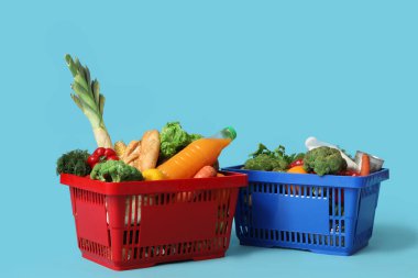 Mavi arka planda yiyecek dolu alışveriş sepetleri