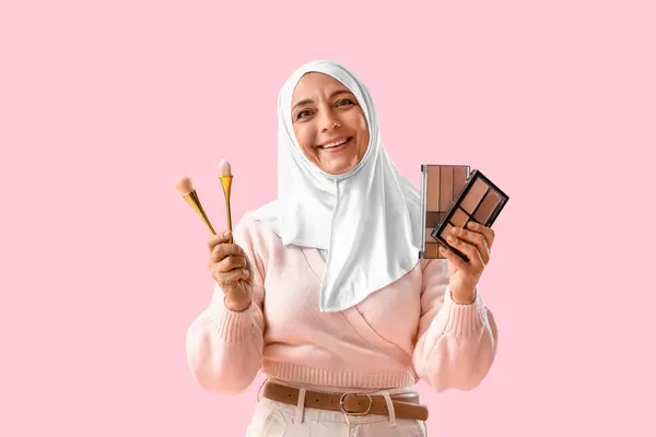 Reife Muslimin Mit Make Pinseln Und Lidschatten Auf Rosa Hintergrund — Stockfoto