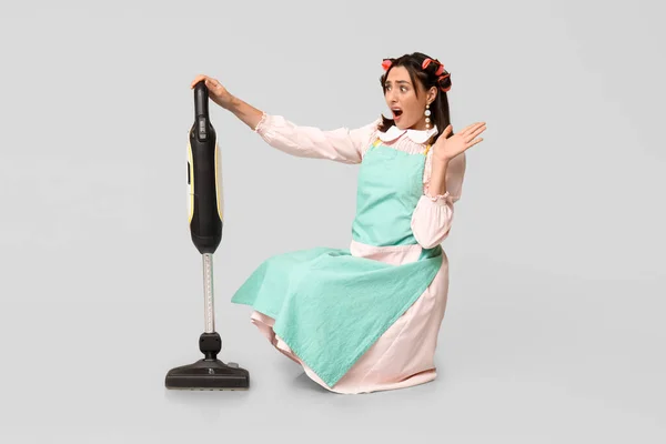 Portrait Shocked Young Housewife Apron Vacuum Cleaner Grey Background — Stock Photo, Image