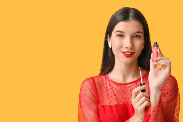 黄色の背景に赤い口紅を持つ美しい若い女性 — ストック写真