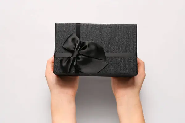 Female hands with gift box on white background. Black Friday