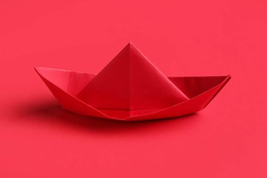 Kırmızı arkaplanda Origami teknesi