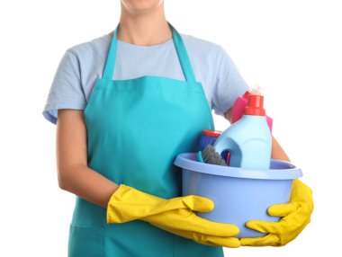 Temizlik işçisi elinde plastik kaseyle beyaz arka planda temizlik malzemeleri tutuyor.