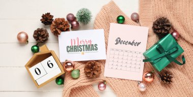 Tebrik kartı, hediye kutusu, süveter, takvim ve dekorasyonlu güzel bir Noel kompozisyonu beyaz ahşap arka planda