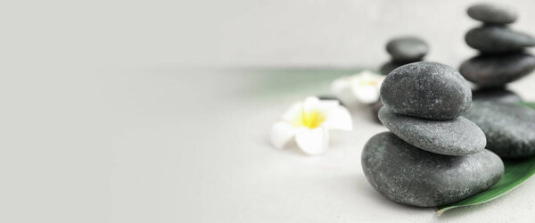 Stack of spa stones on light background with space for text
