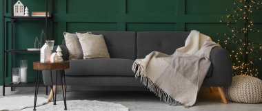 Gri kanepesi ve Noel süslemeleri olan oturma odasının içinde.