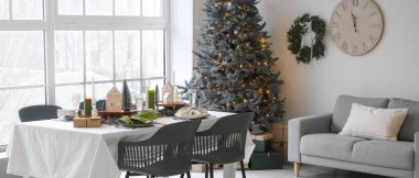 Aydınlık oturma odasında Noel masası.