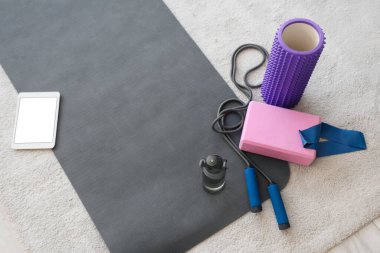 Evde bir şişe su bulunan spor aletleri.