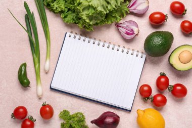 Boş tarif kitabıyla kompozisyon ve arka planda taze sebzeler