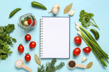Renkli arka planda boş tarif kitabı, baharatlar, otlar ve sebzelerle kompozisyon