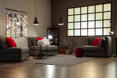 Gri koltukları ve sehpasında disko topu olan modern oturma odasının içinde.