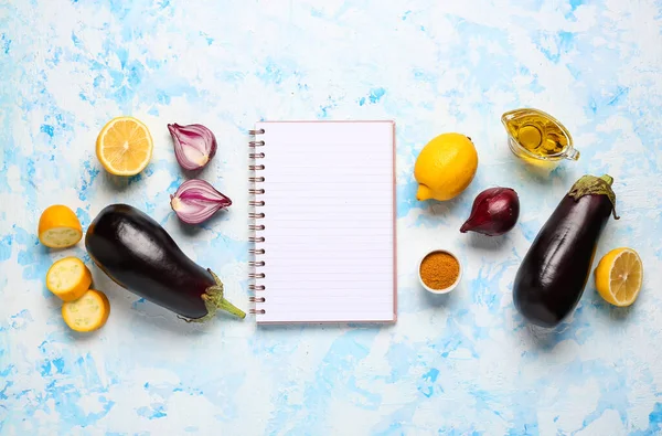 Composition with blank recipe book and vegetables on color background