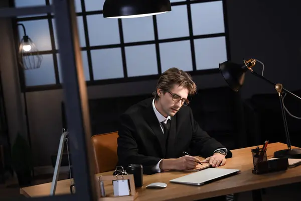 Young businessman working in office at night