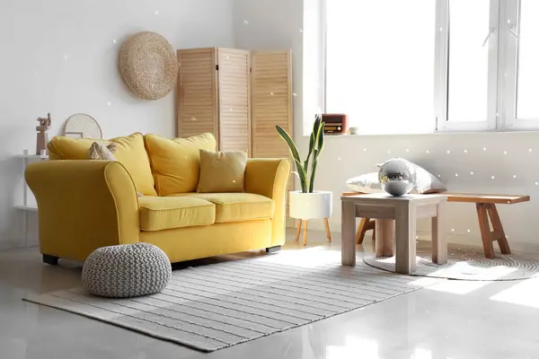 Interior of modern living room with yellow sofa and disco ball on coffee table