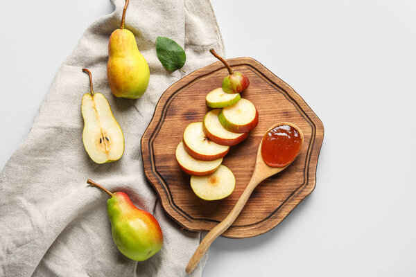 Wooden board with spoon of tasty pear jam on white background