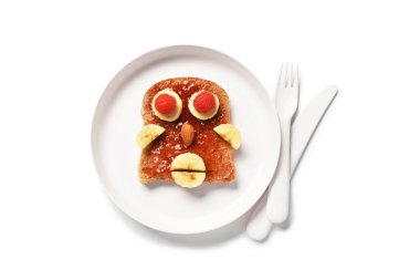 Beyaz arka planda insan yüzü şeklinde komik çocuk kahvaltısı tabağı.
