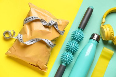 Spor ekipmanları ve renkli arka planda sağlıklı atıştırmalıklar.