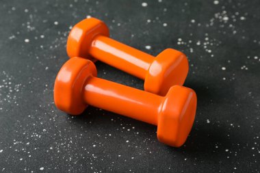 Siyah arkaplanda turuncu halterler