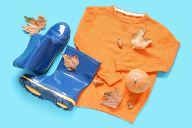 Sonbahar yapraklı mavi çizmeler, renkli balkabağı ve süveter.