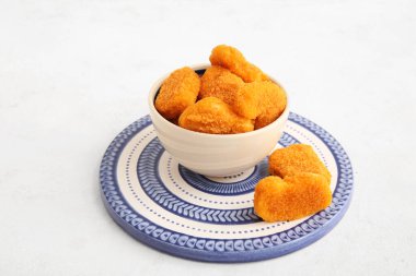 Beyaz arka planda lezzetli nuggetlar olan kase