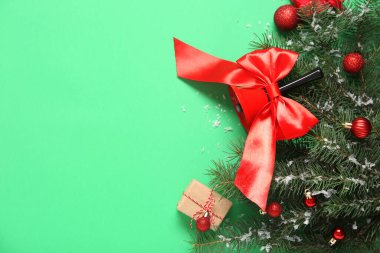 Köknar dalları ve yeşil arka planda topları olan Noel çanı