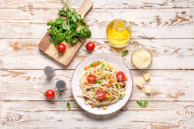Lezzetli makarnalı primavera tabağı ve beyaz ahşap arka planda malzemeler.